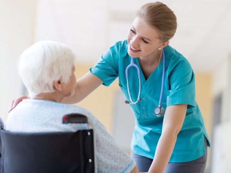 Senior woman in wheelchair with nurse in hospital